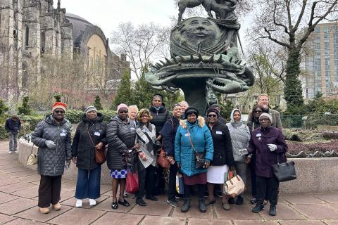 Members of the Diocesan Altar Guild stand outside a statue at St. John the Divine