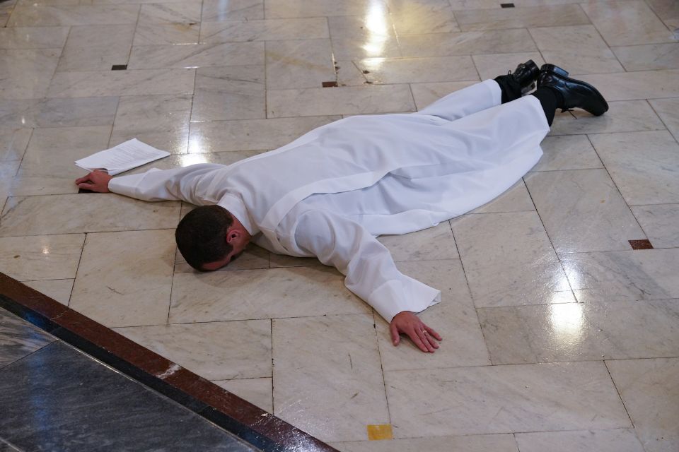 A candidate lies in prayer face down