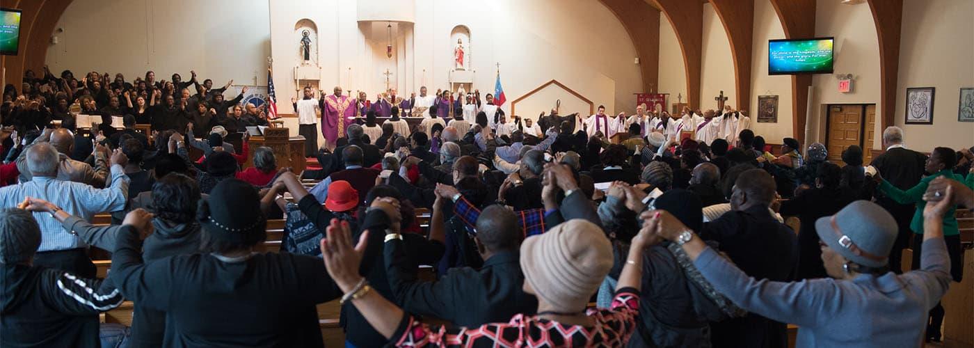 A congregation holding hands in prayer