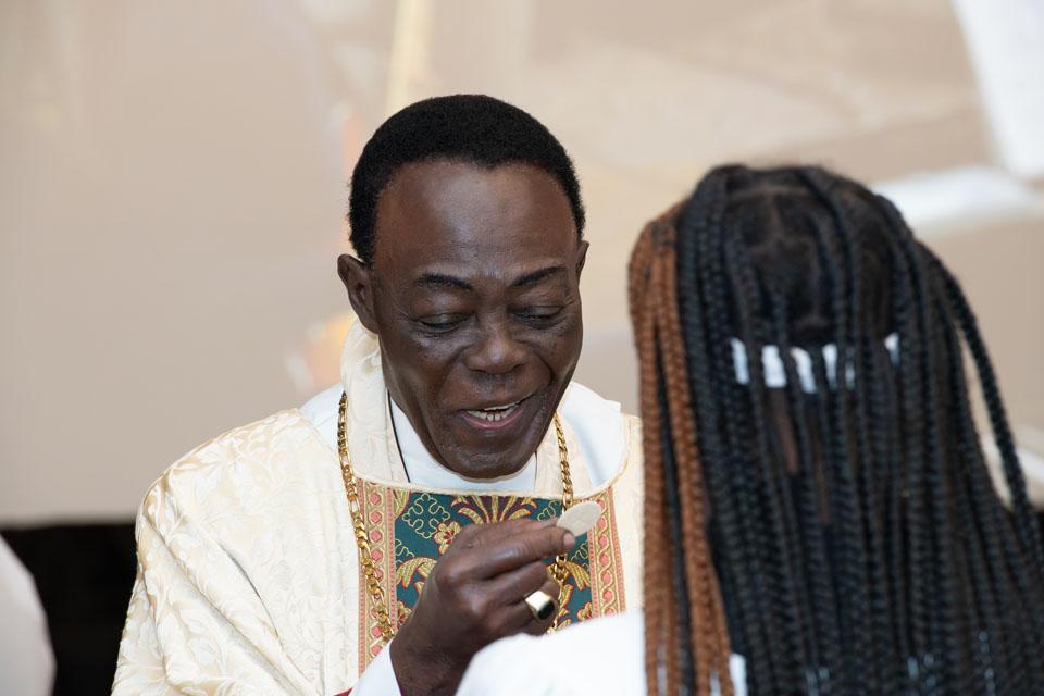 Bishop Allotey distributes the Holy Eucharist