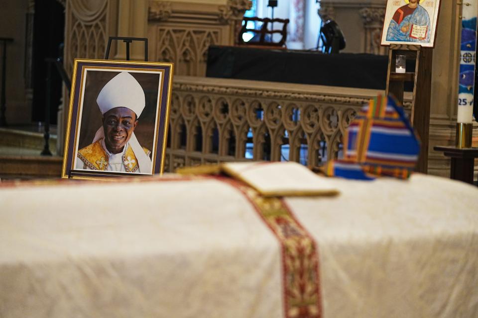 A portrait of Bishop Allotey behind his casket at his funeral.