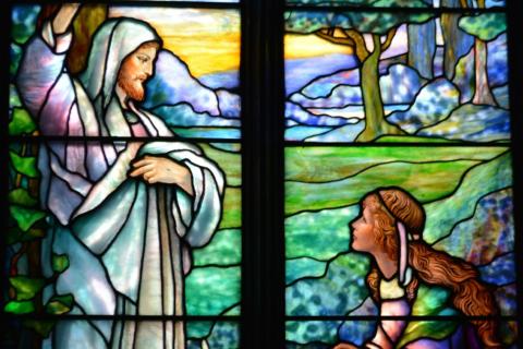 A picture of a stained glass window: Jesus greets Mary in the Garden