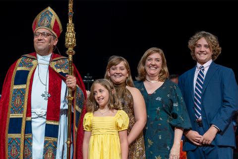 Bishop Shoemaker stands with his family on stage at his Consecration